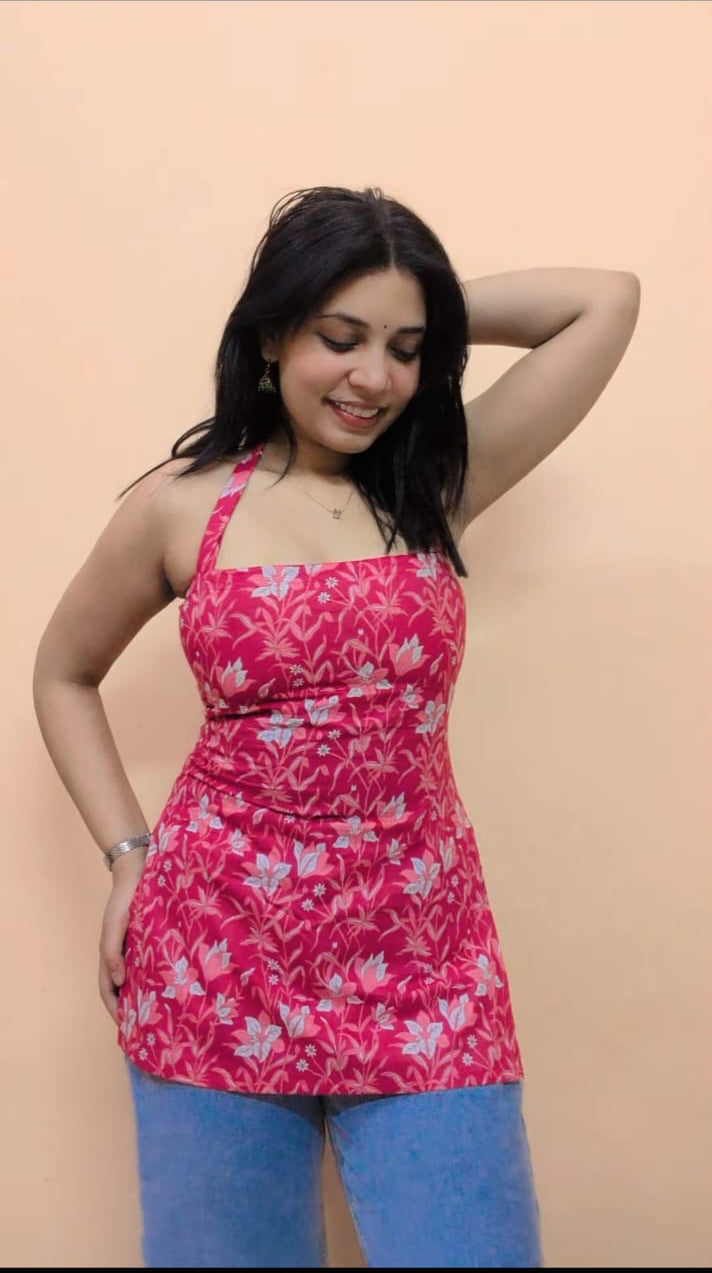 Woman wearing a pink floral dress against a beige background